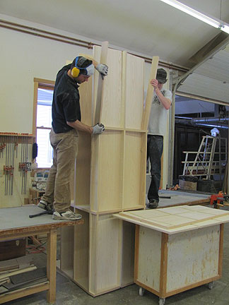 Saer and Ethan working on a bookcase, on end