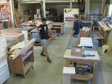 Furniture makers at Huston and Company hustle in the workshop